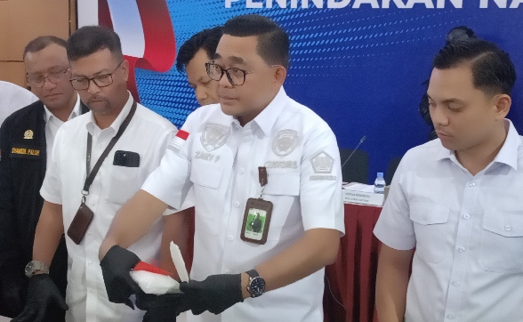 Kepala Kantor BC Batam, Zaky Firmansyah saat mempraktikkan cara An sembunyikan sabu di sepasang sandal jepit. Foto Ist : doc/red.